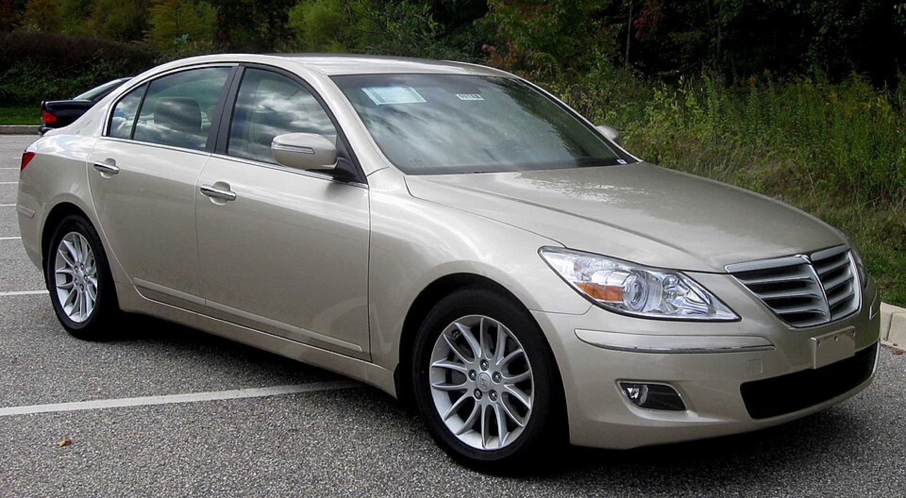 A first-generation Hyundai Genesis sedan parked outdoors, showing typical plate mounting locations on the front and rear.