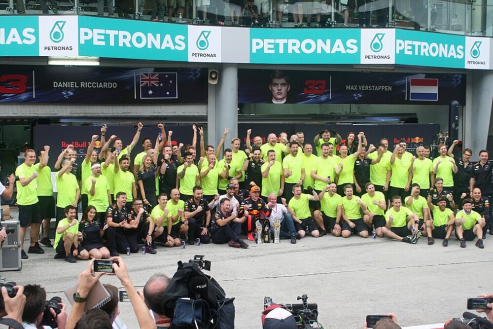 Red Bull Racing team celebrating at a Grand Prix, highlighting official team apparel vs fan jackets