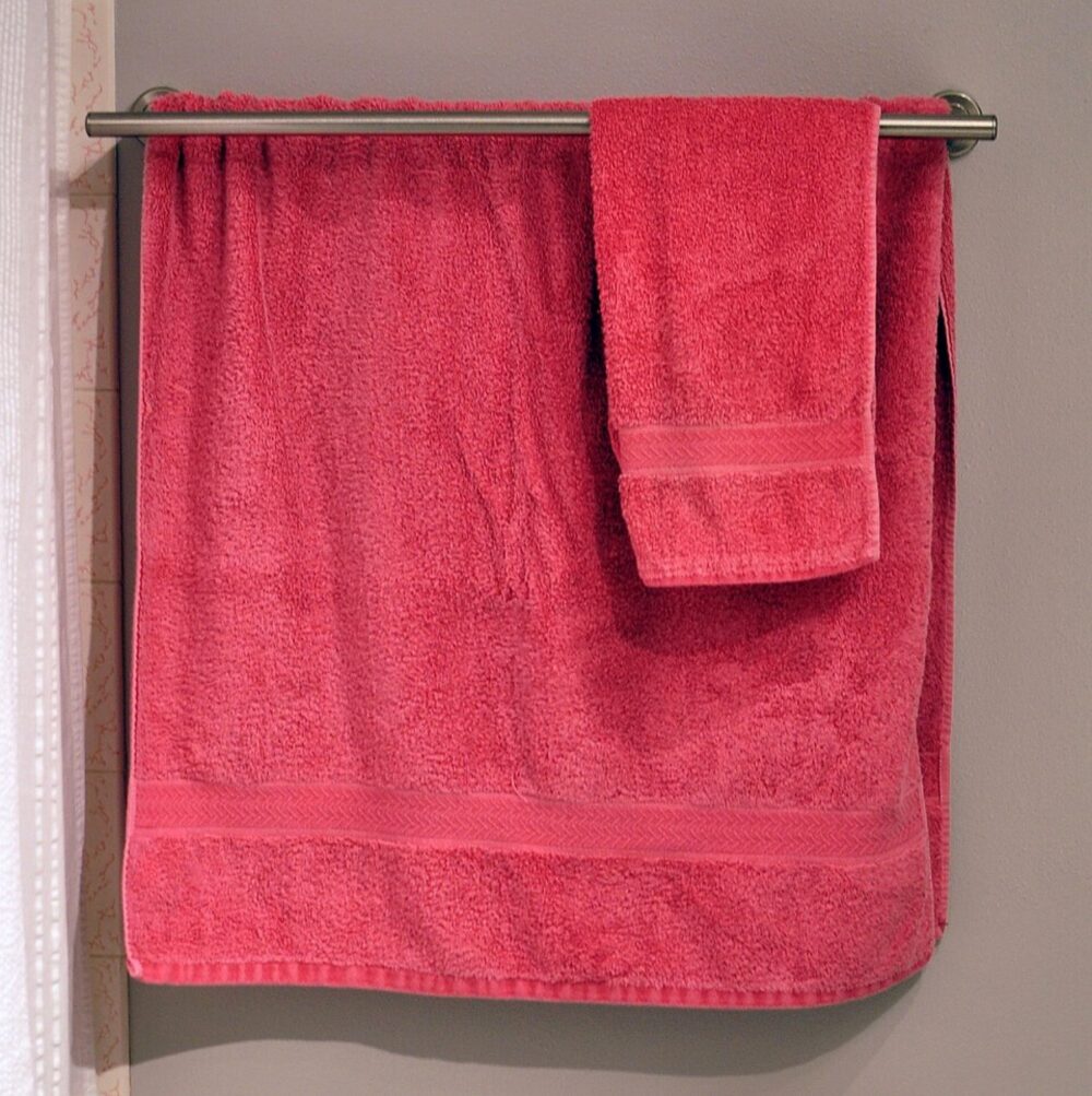 Stack of white and colored towels hanging in a bathroom