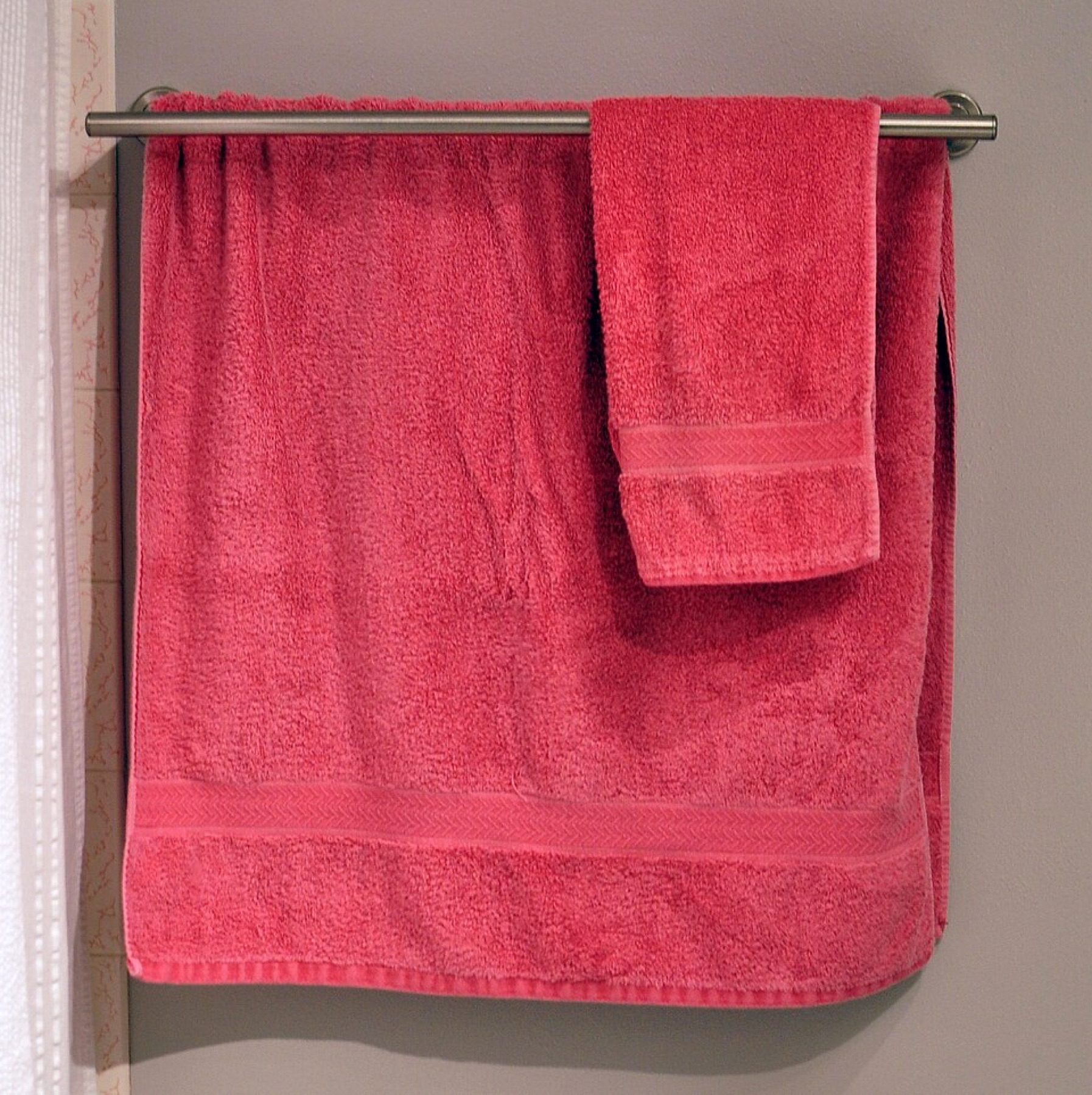 Stack of white and colored towels hanging in a bathroom
