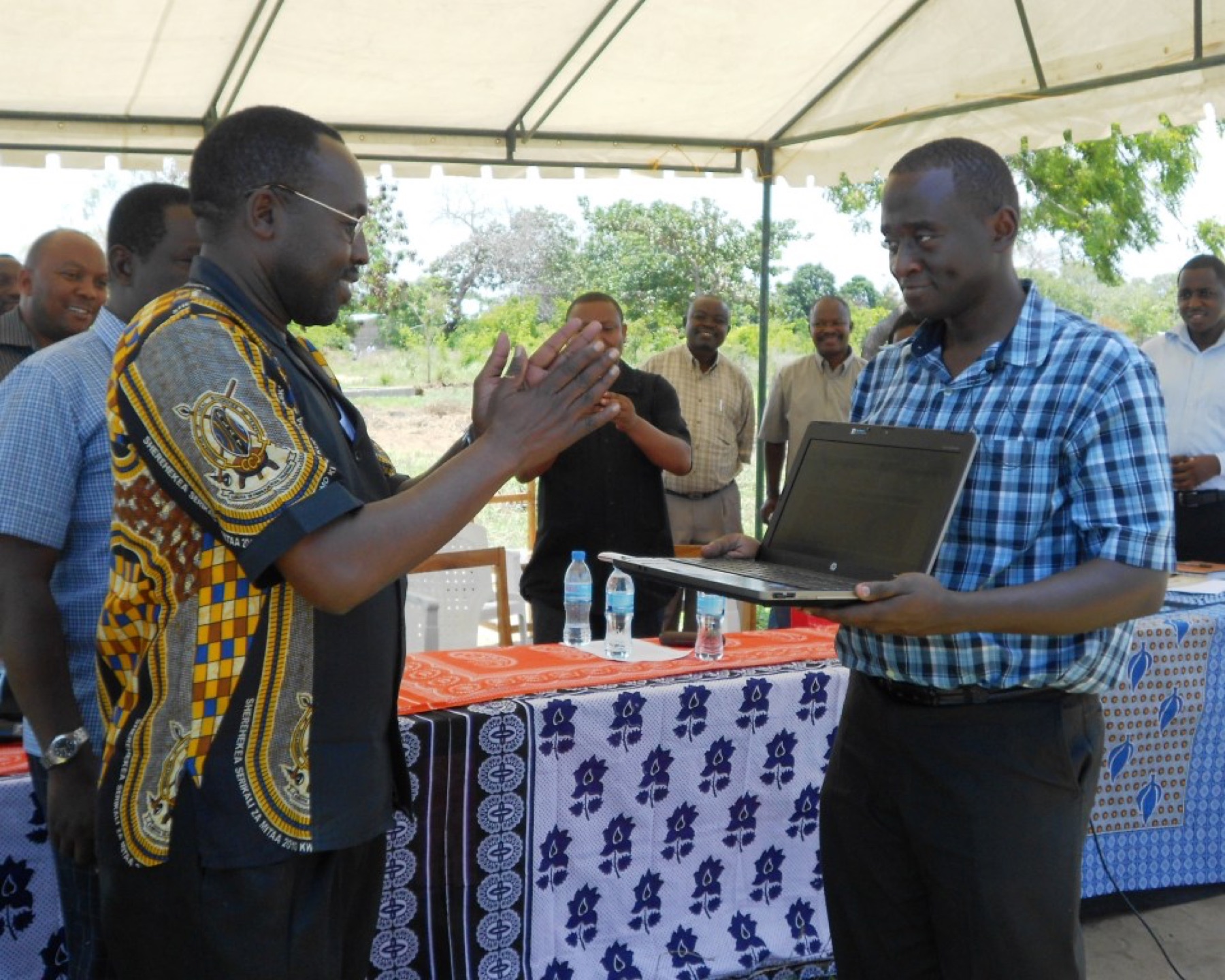 People in a village discussing a new online platform on a shared screen
