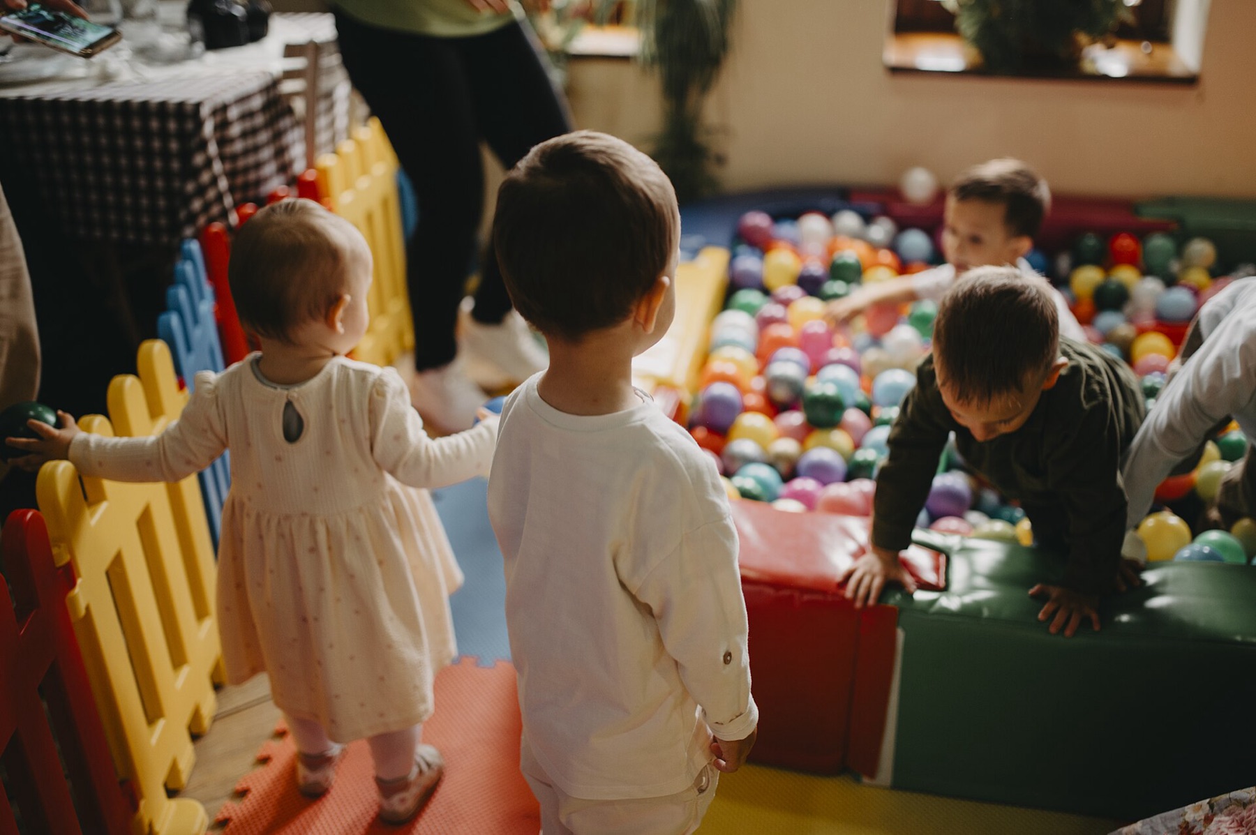 Children playing in a colorful indoor ball pit play area
