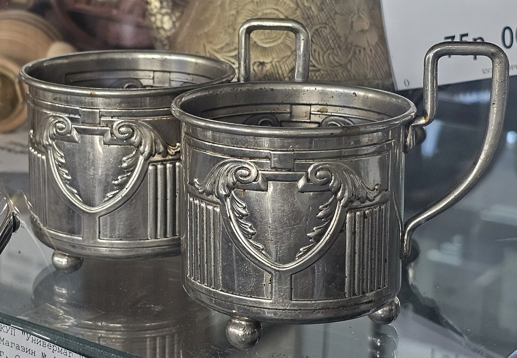 Shelves of metal and glass tea holders showing style and size variety