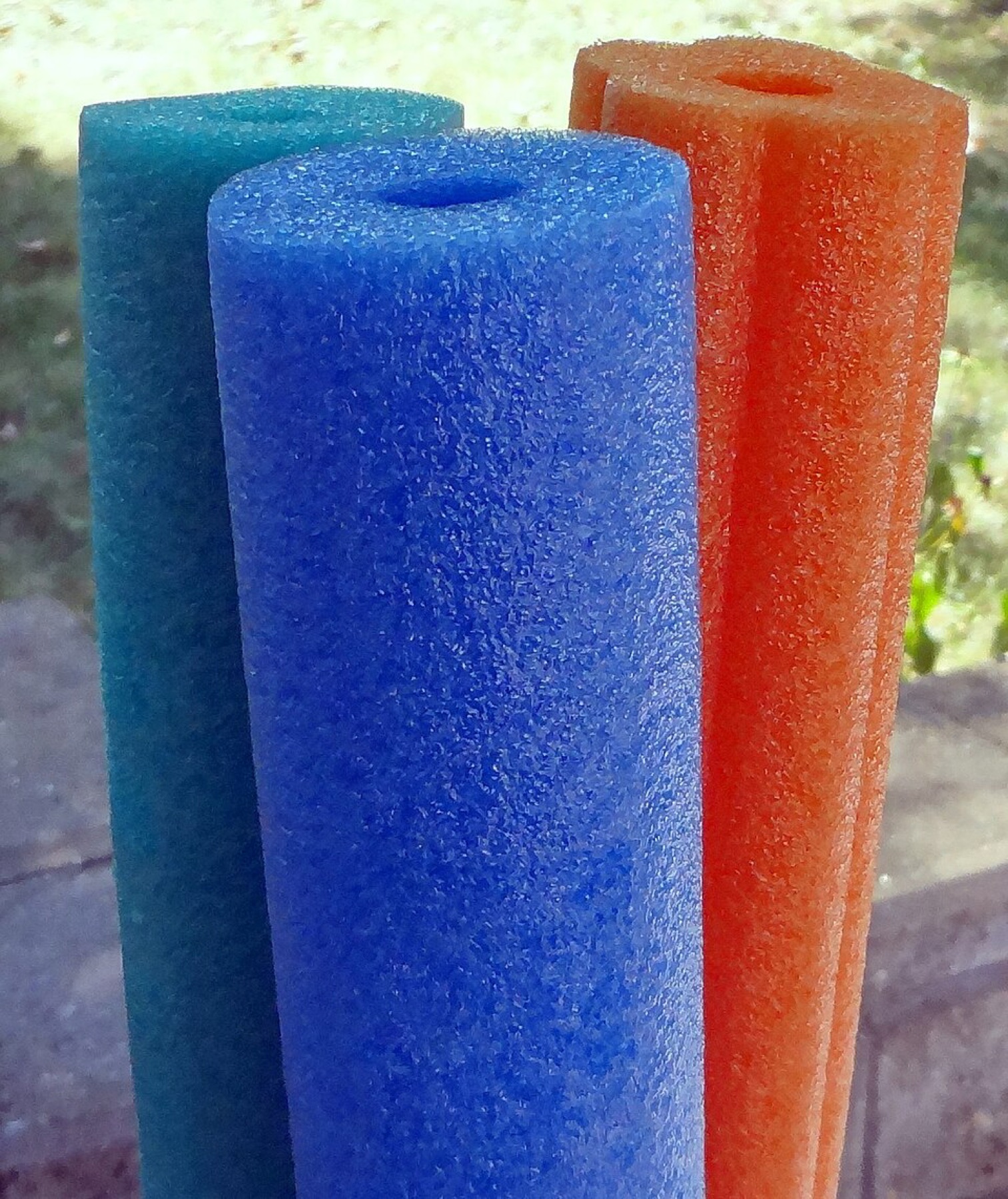 Assorted colorful foam pool noodles stacked together