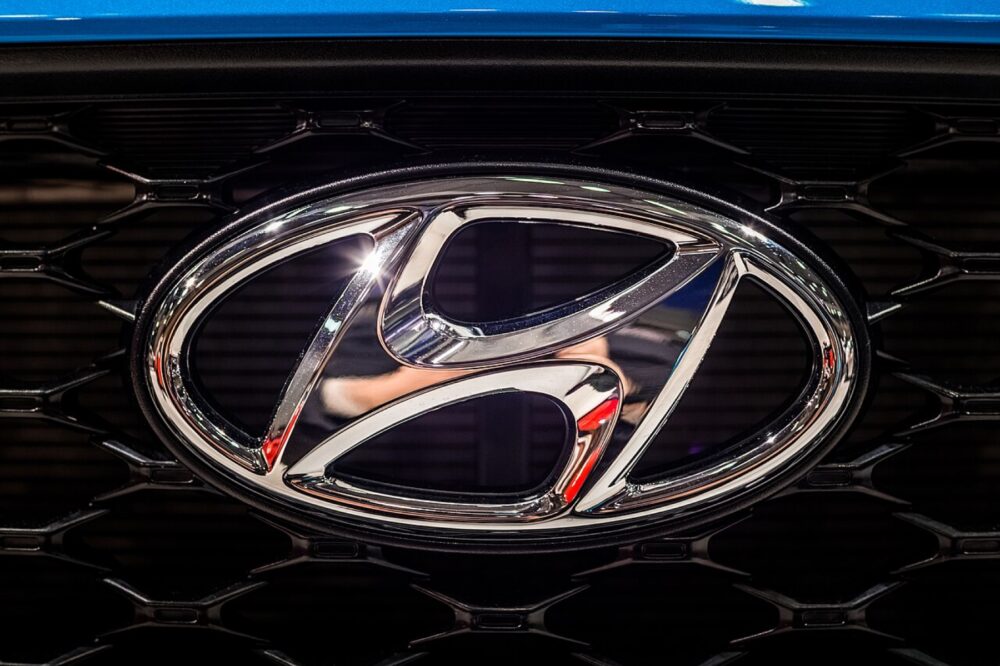Close-up of a Hyundai badge on a vehicle, used as an editorial reference for shape, finish, and mounting context