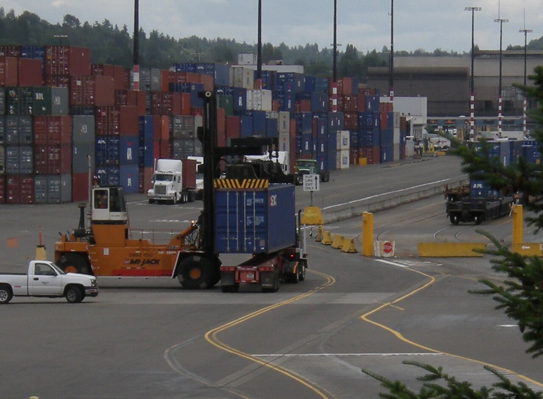 A shipping container being transferred between vehicles at a freight terminal, illustrating cross-border supplier logistics