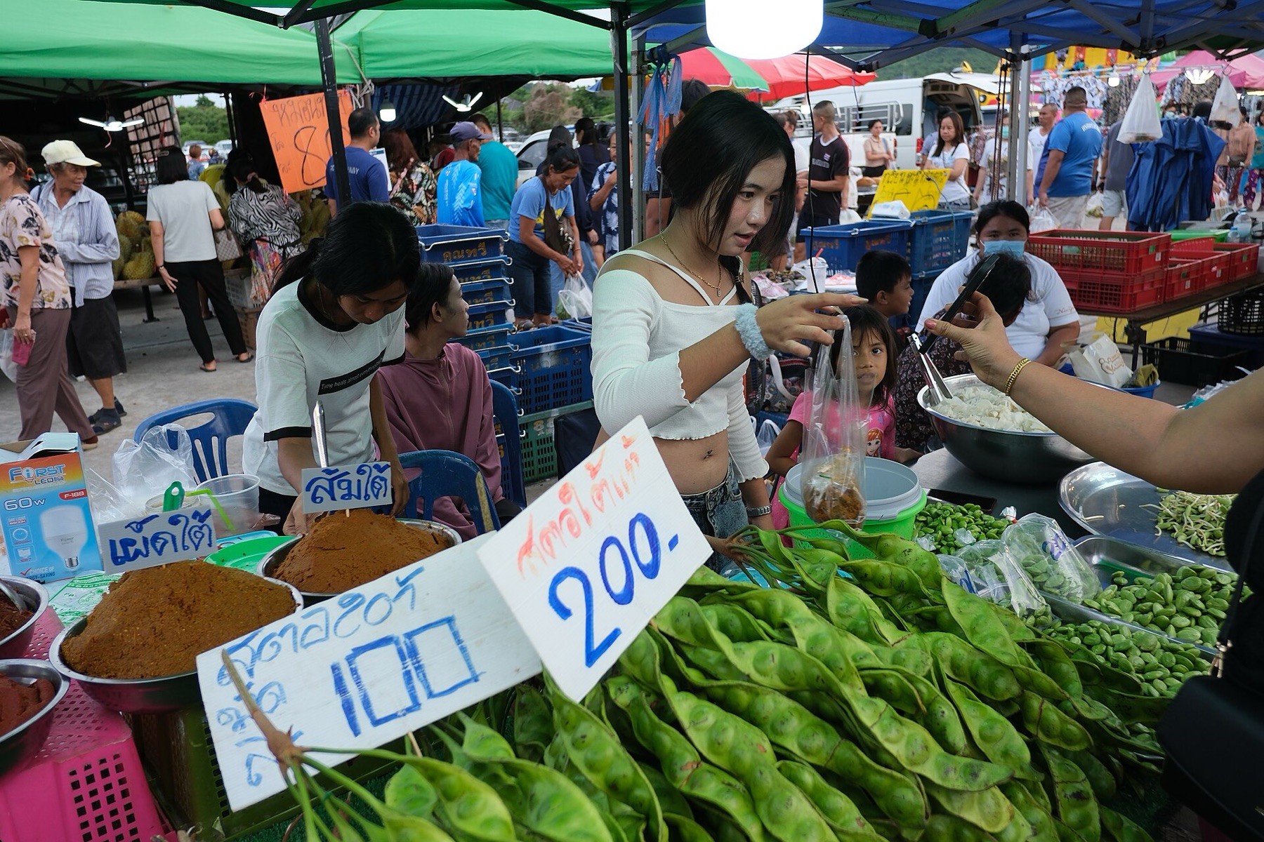 Outdoor market with multiple vendor tents and canopies, showing typical booth structures