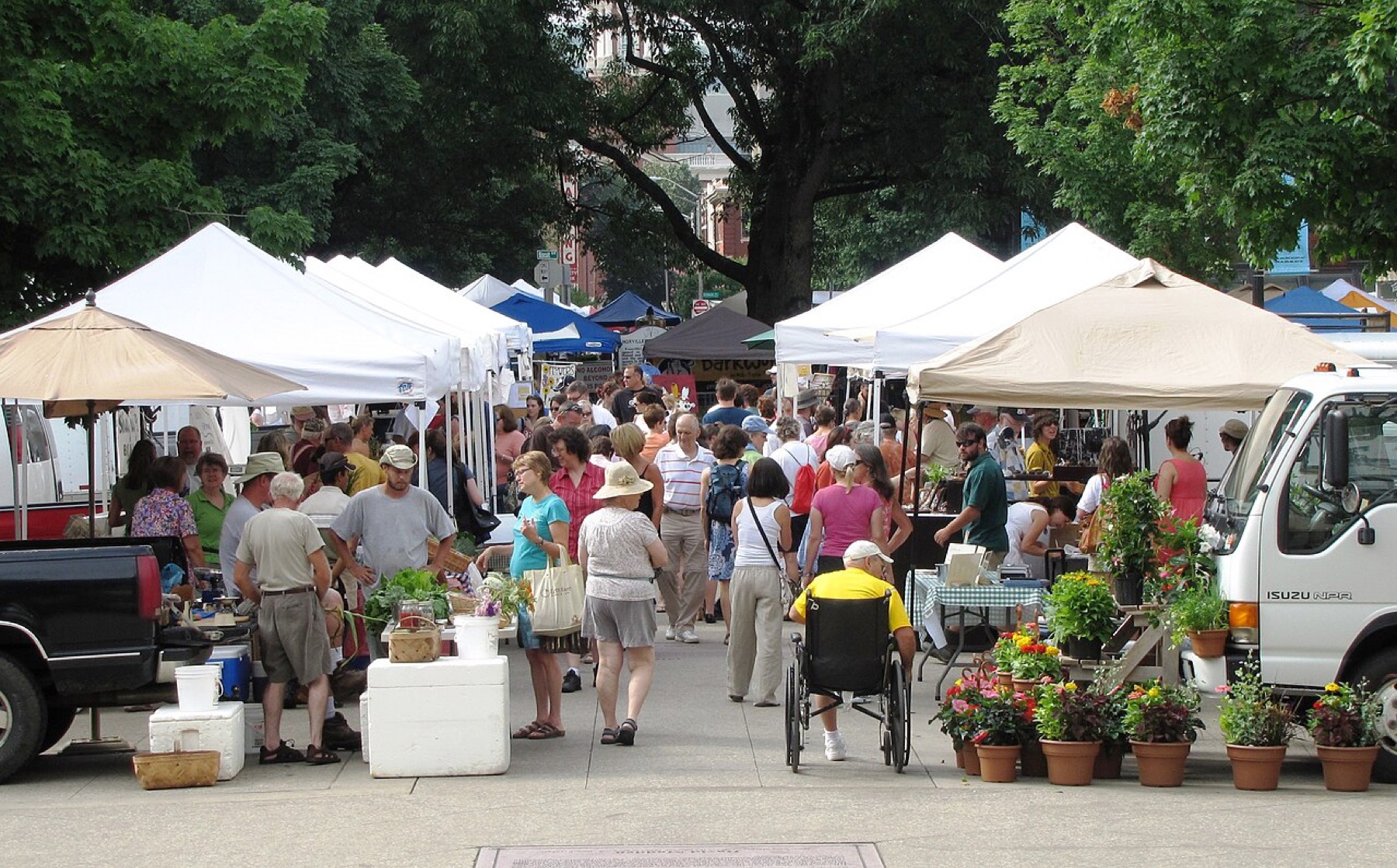 Street vendors operating under canopy tents in a public square