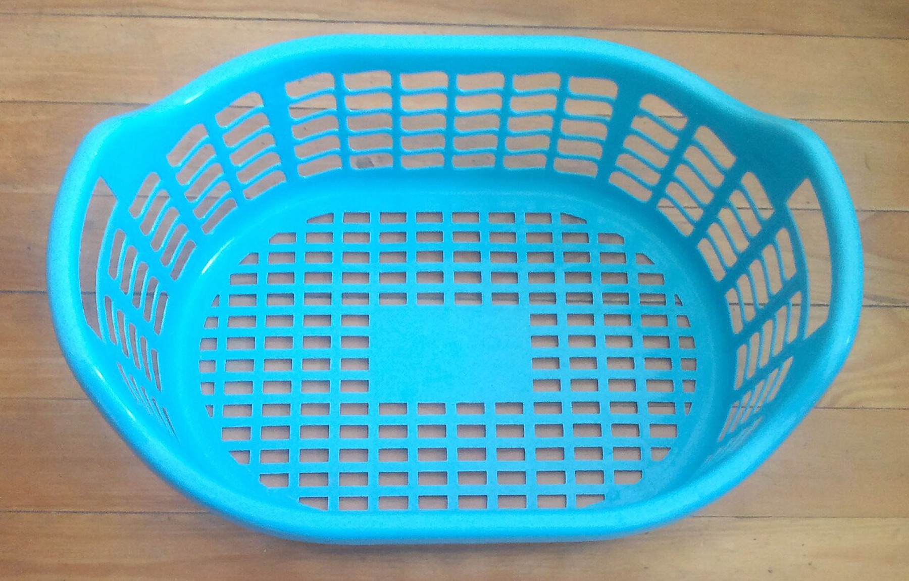 Plastic laundry basket sitting on the floor