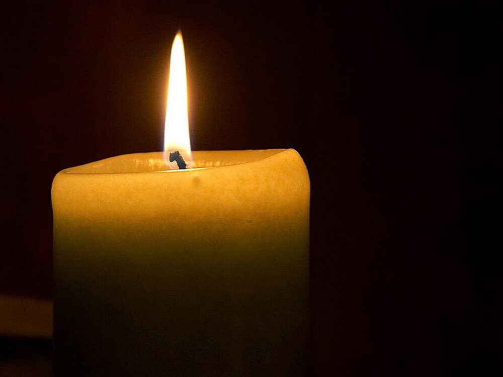 Close-up of a single candle flame, representing simple bulk candles used as wedding favors