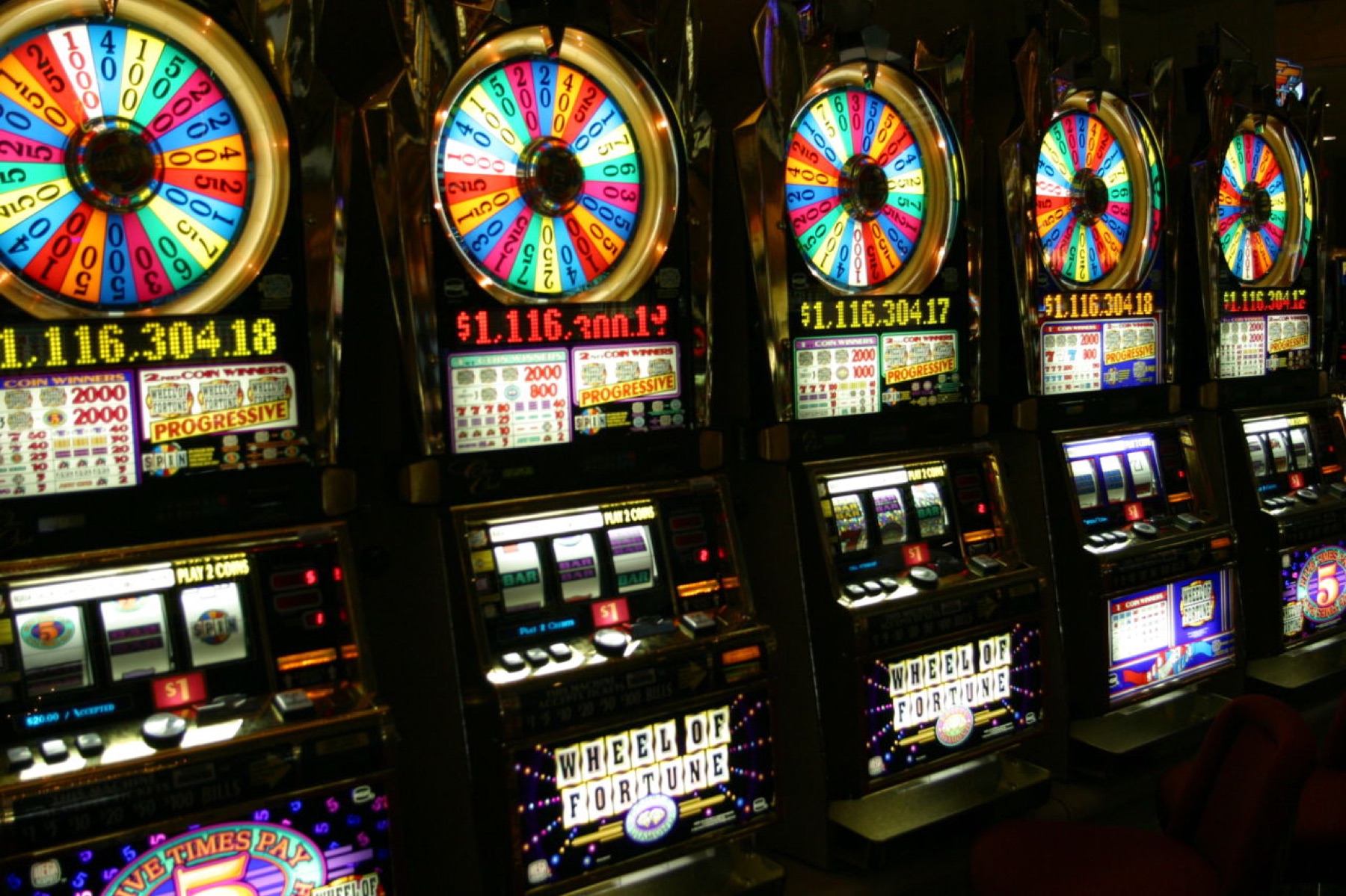 Row of traditional slot machines in a casino environment