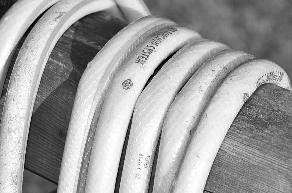 Close-up of a garden hose coiled on wooden boards