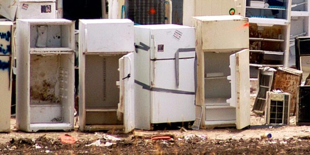 Technician working on a home appliance with internal parts exposed