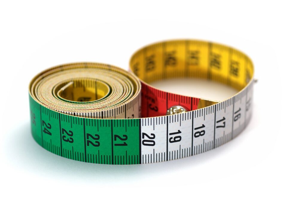 Three colored flexible tape measures coiled together