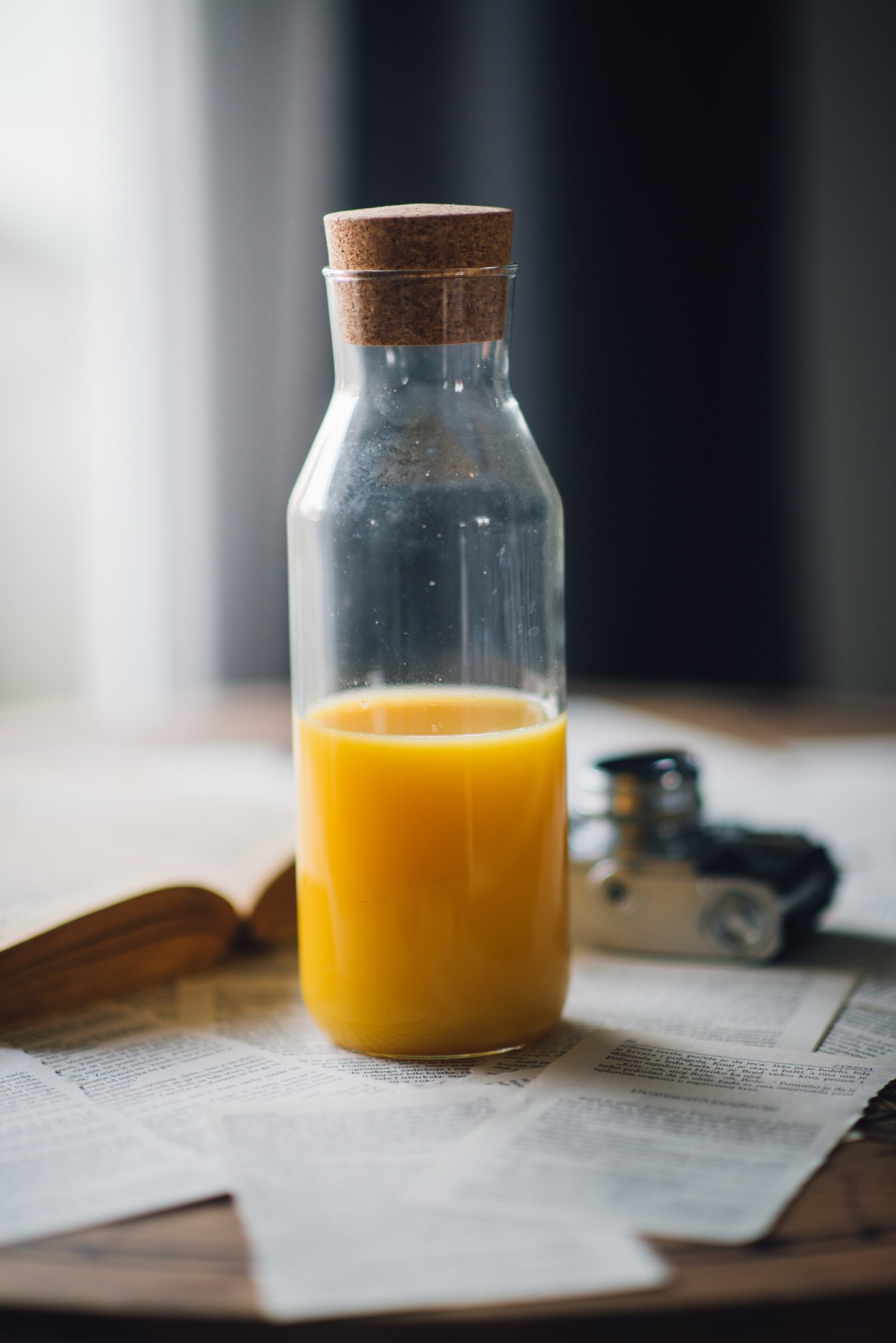 Glass juice bottle with orange juice on a table