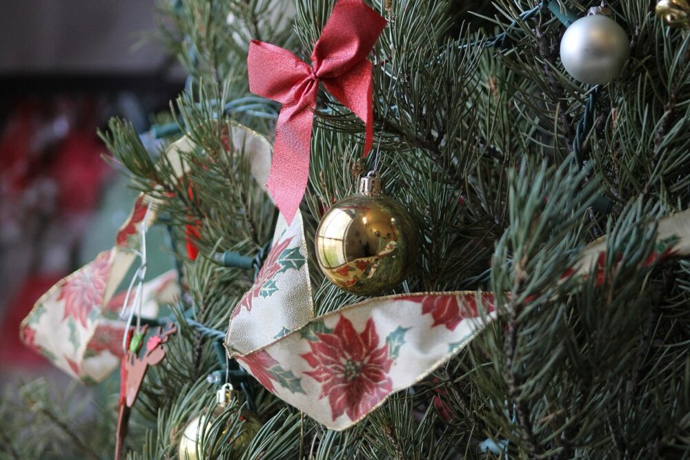 Close-up of a Christmas ornament hanging on a lit tree