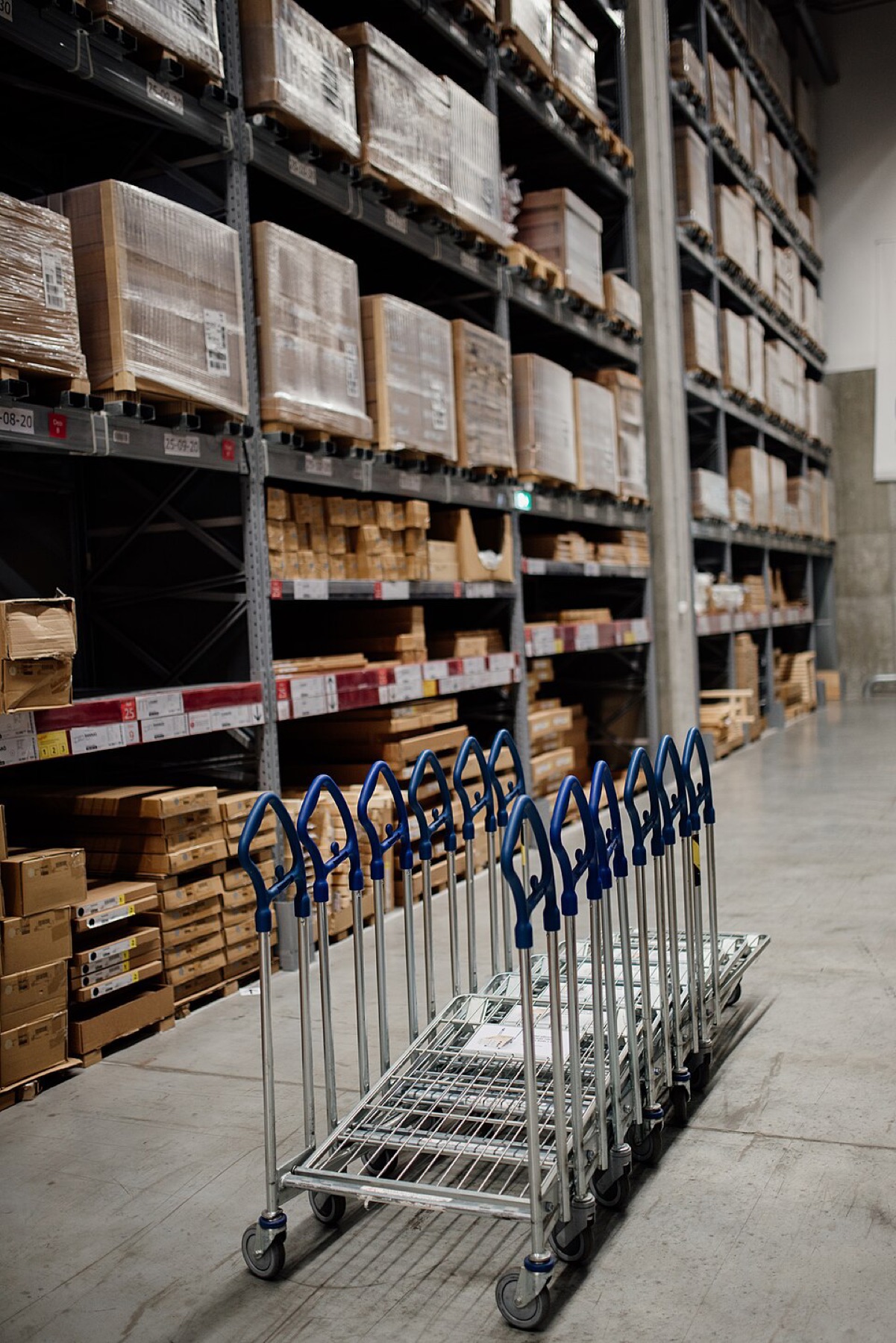 Warehouse shelves stocked with boxes and carts for inventory handling