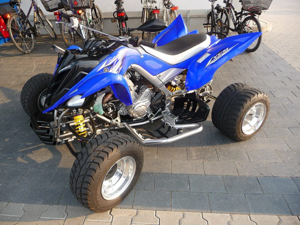 Yamaha Raptor sport ATV parked on grass, side view