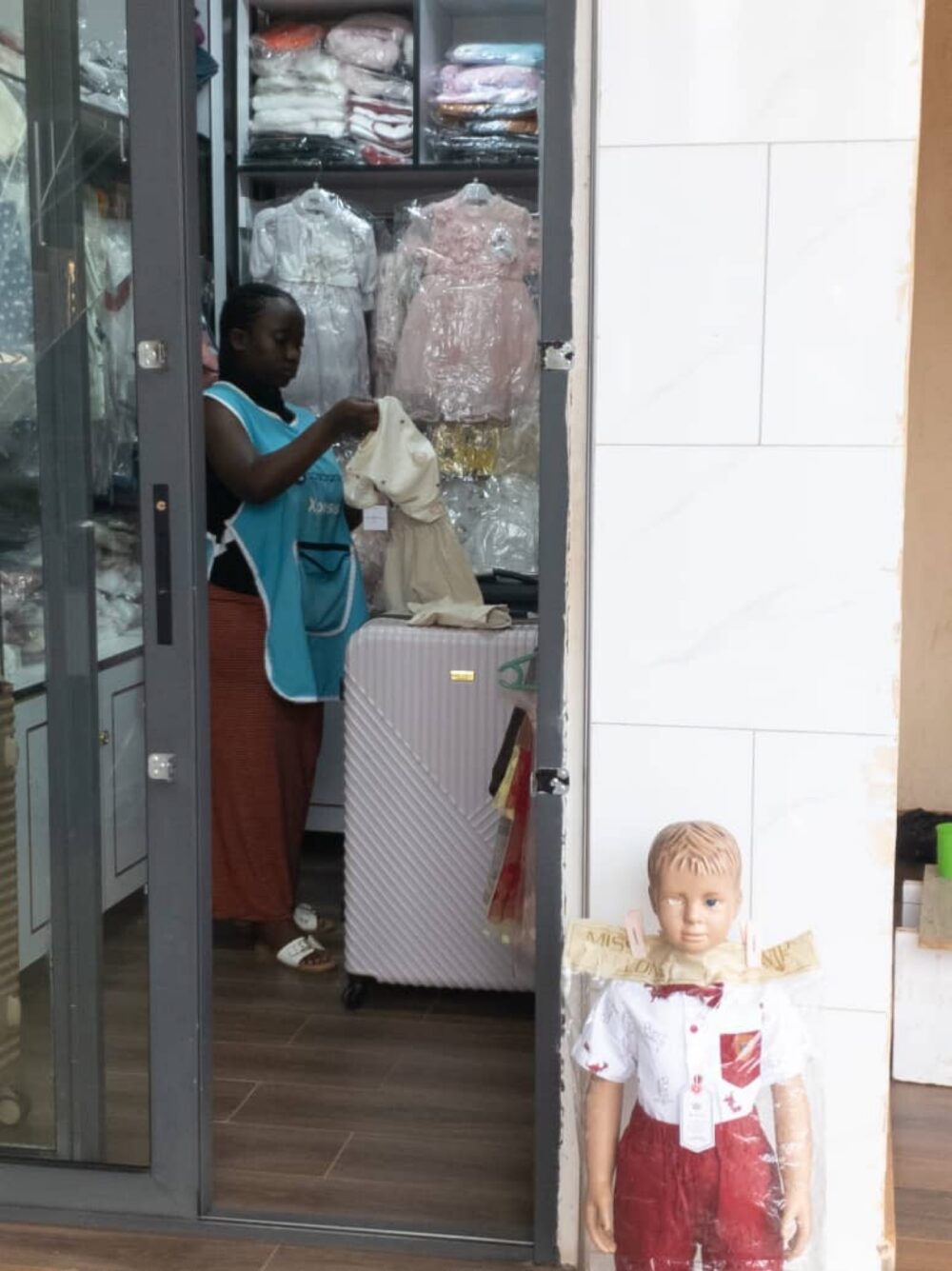 Shop attendant organizing children's clothes for display