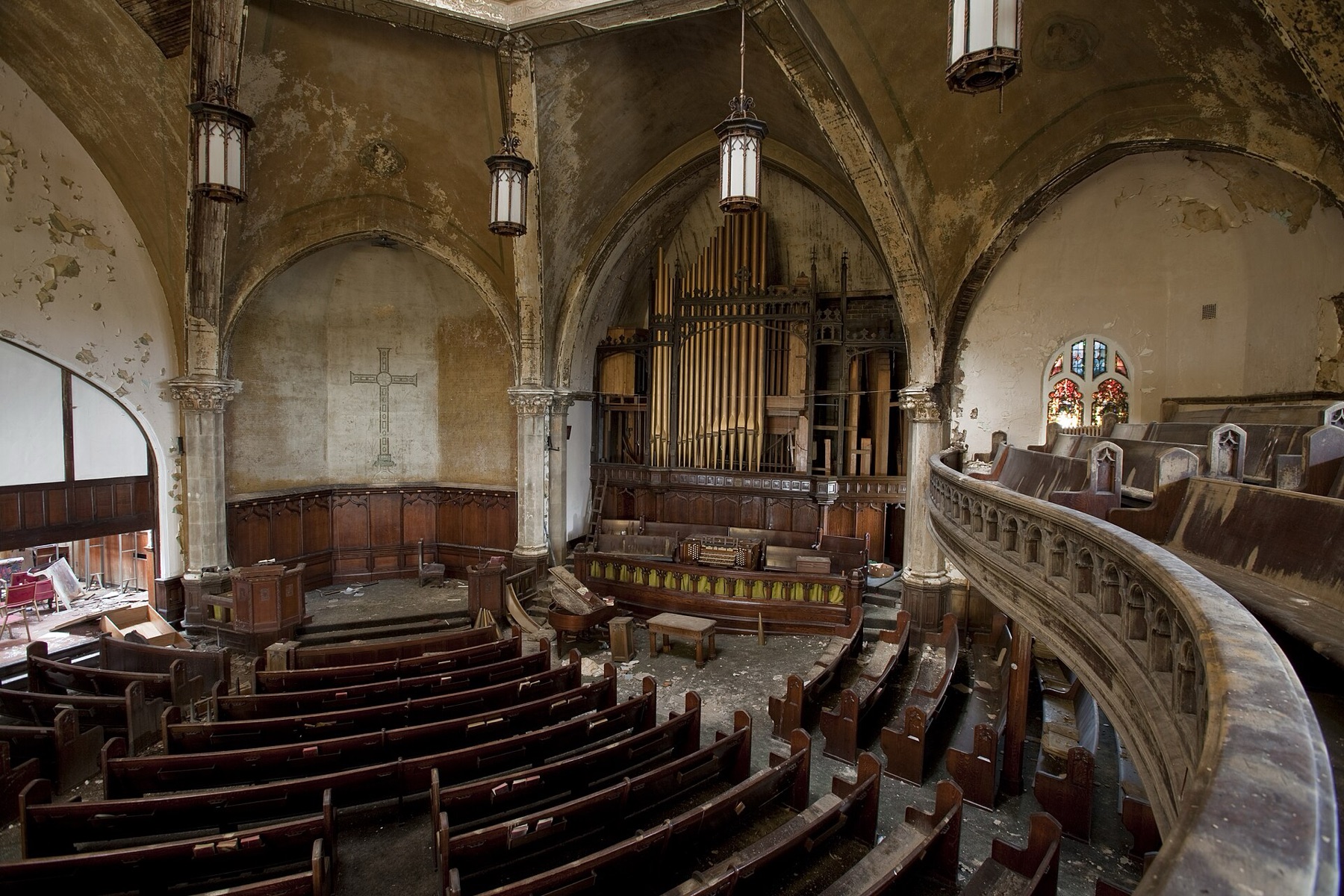 Traditional wooden pews viewed from a church balcony, illustrating fixed bulk seating and aisle layout.
