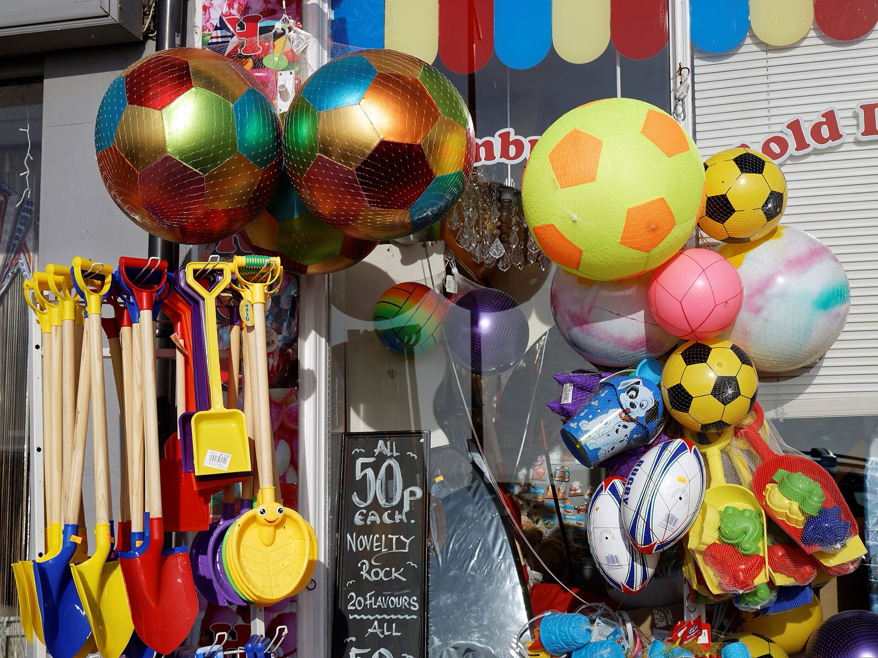 Assorted balls and toys on a beach stall, illustrating variety of ball-style play items