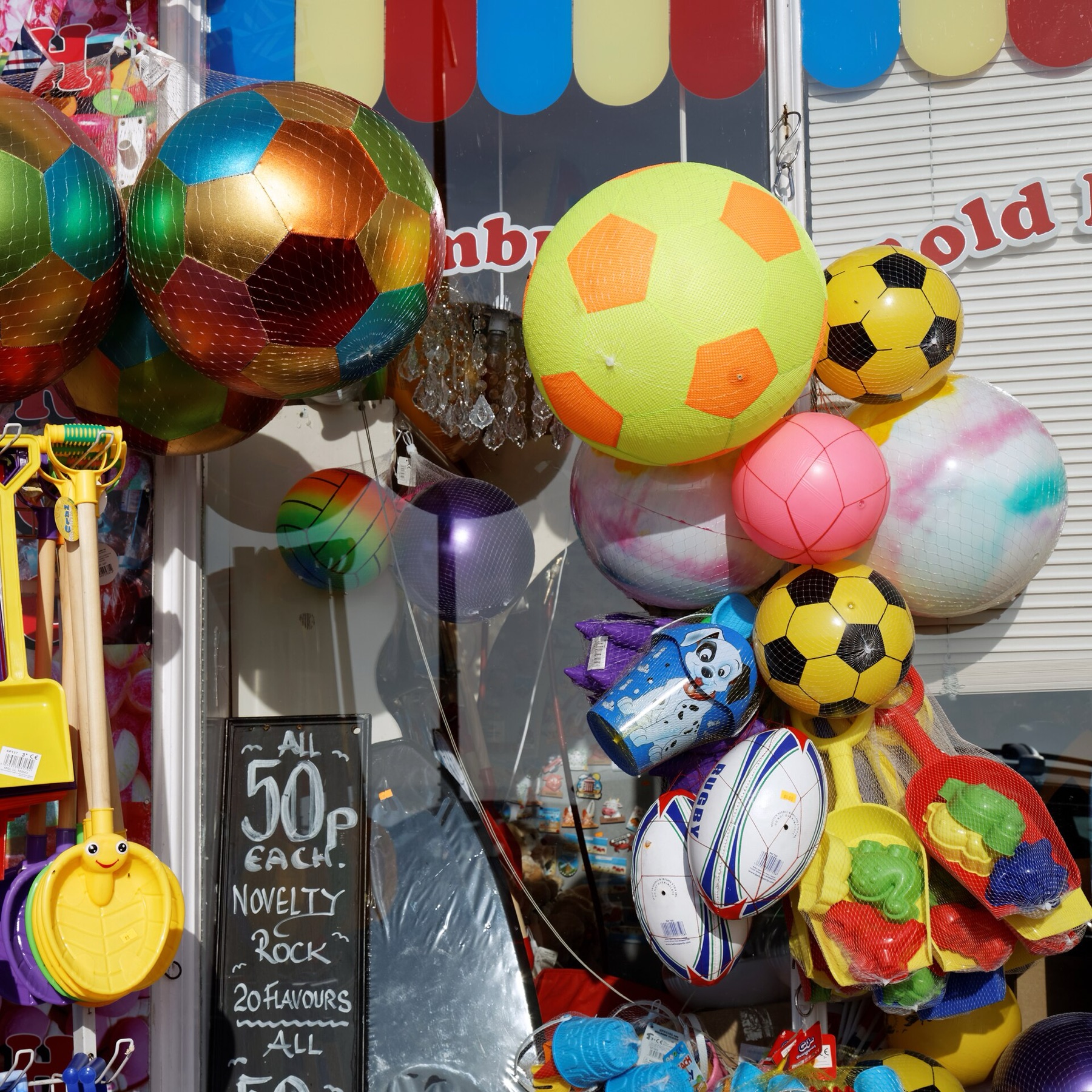 Bulk balls and toys displayed in a seaside shop, illustrating varied toy inventory similar to dog ball assortments