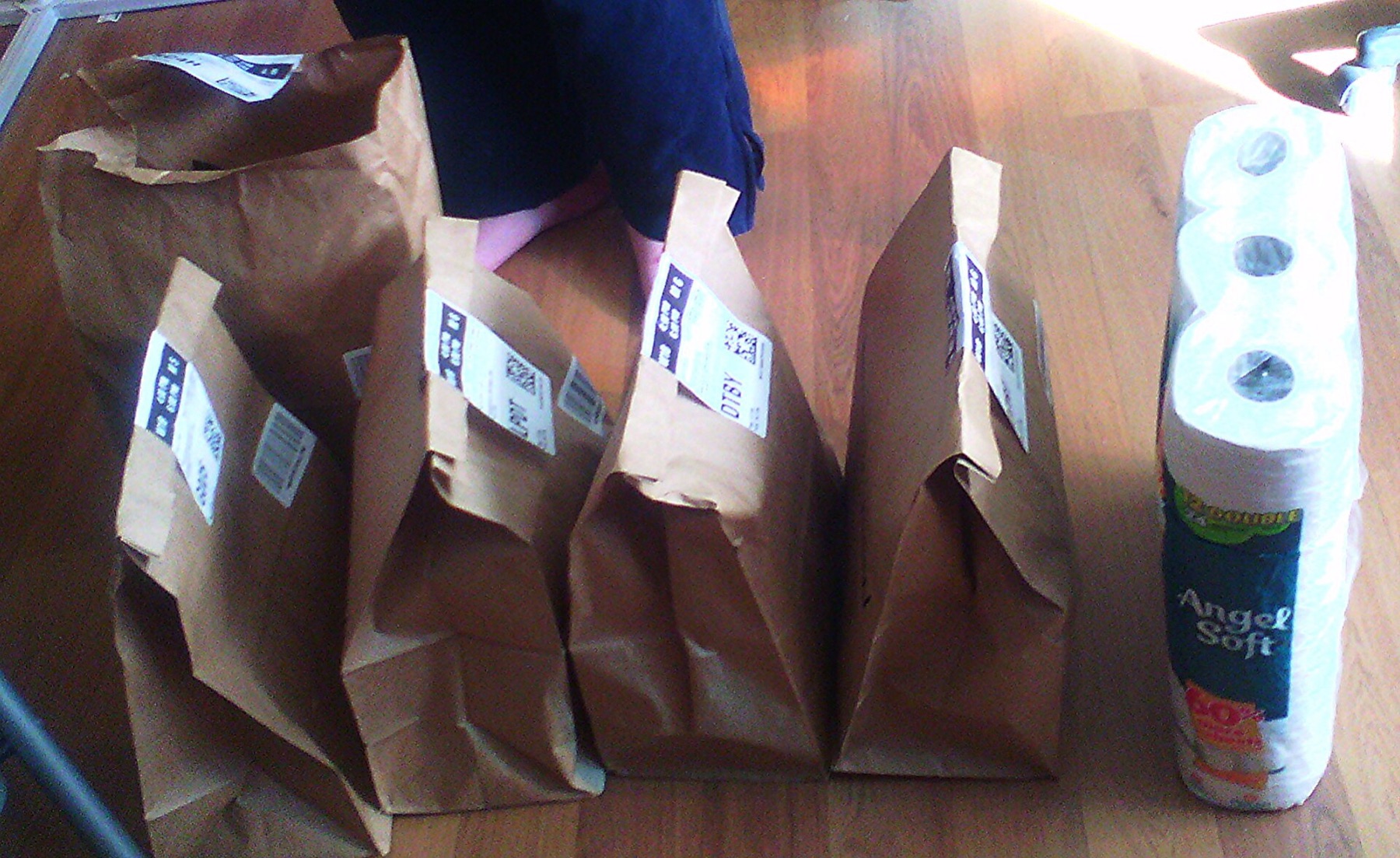 Amazon-branded grocery delivery bags stacked on a doorstep, illustrating Amazon’s role as a delivery marketplace rather than a single catering bag program.