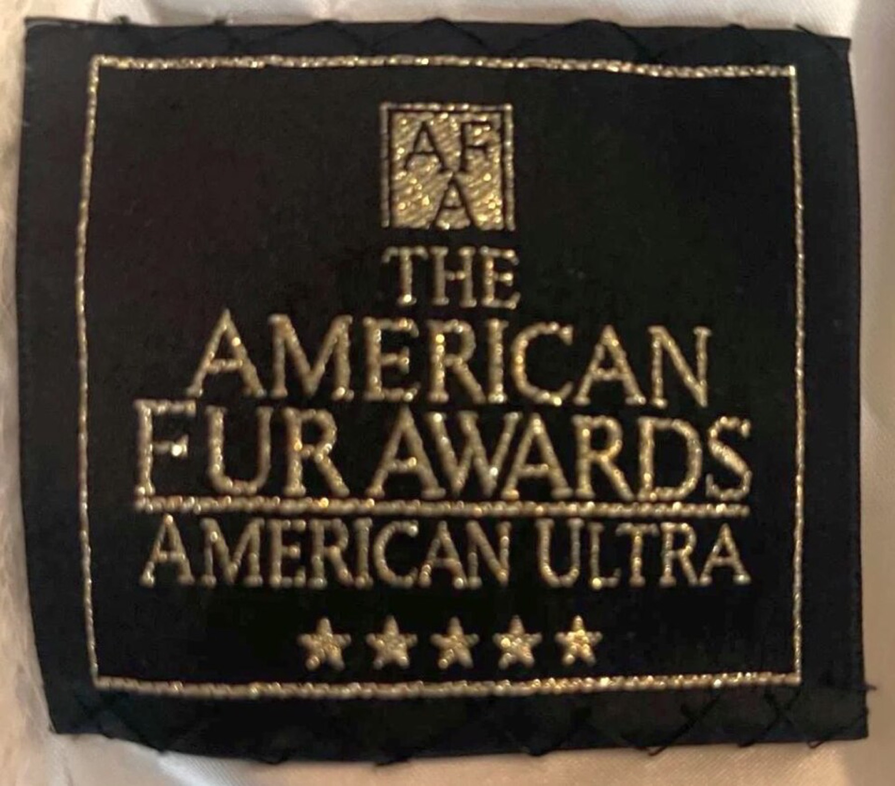 Close-up of a cloth award label sewn into a garment, showing typical award branding.