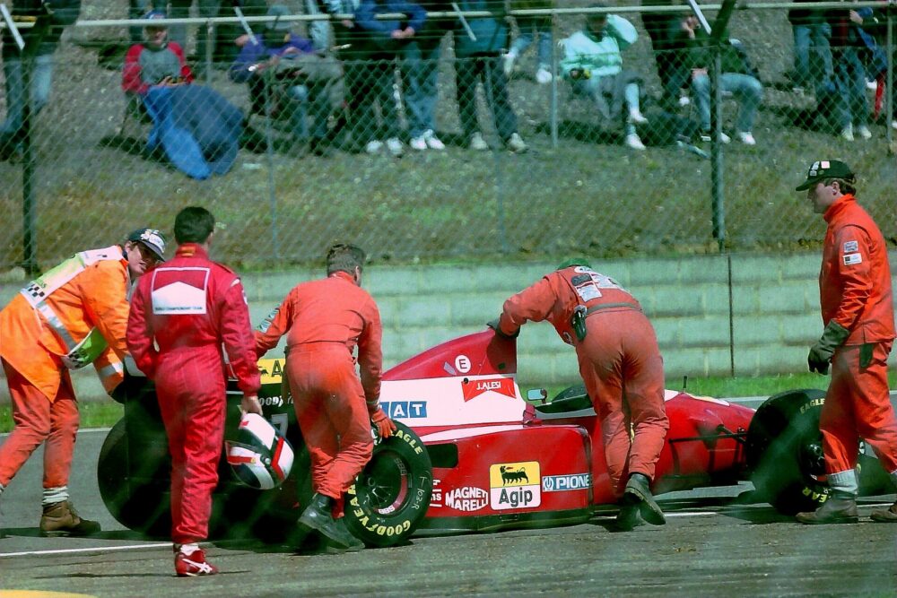 Ferrari F93A Formula 1 car being pushed away as driver Jean Alesi looks on, illustrating Ferrari’s racing heritage that inspires branded watches
