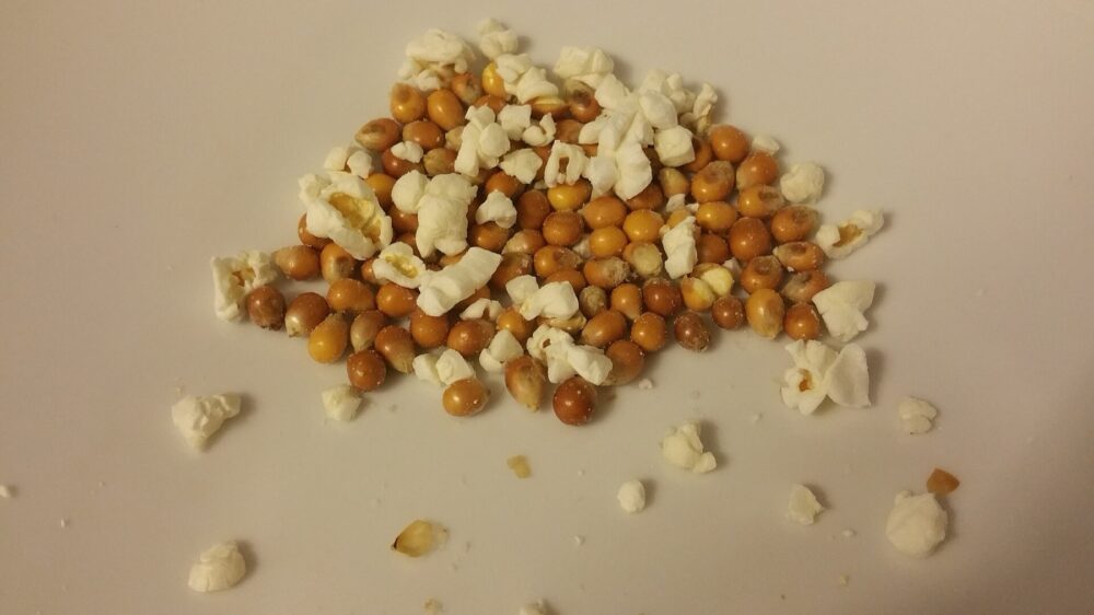 Close-up of popcorn spilling out of a serving container, illustrating volume and container type