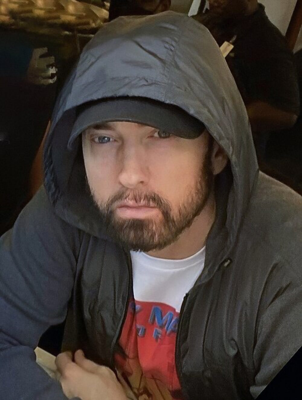 Editorial image of Eminem wearing streetwear, thematically linking beanies and merch