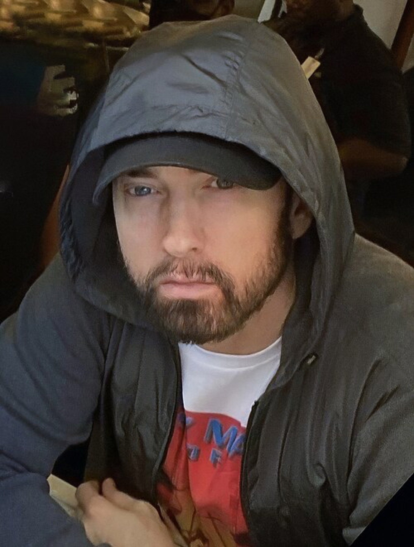 Editorial image of Eminem wearing streetwear, thematically linking beanies and merch