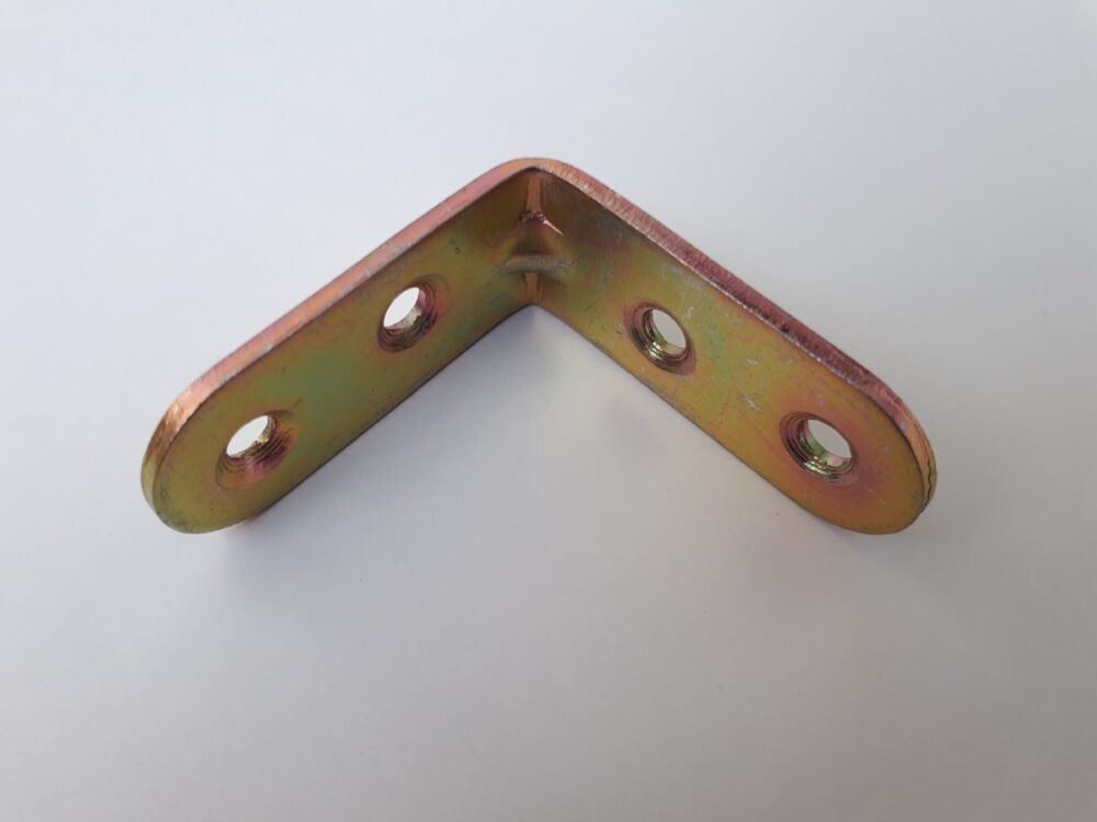 Small bronze angle bracket resting on a flat surface