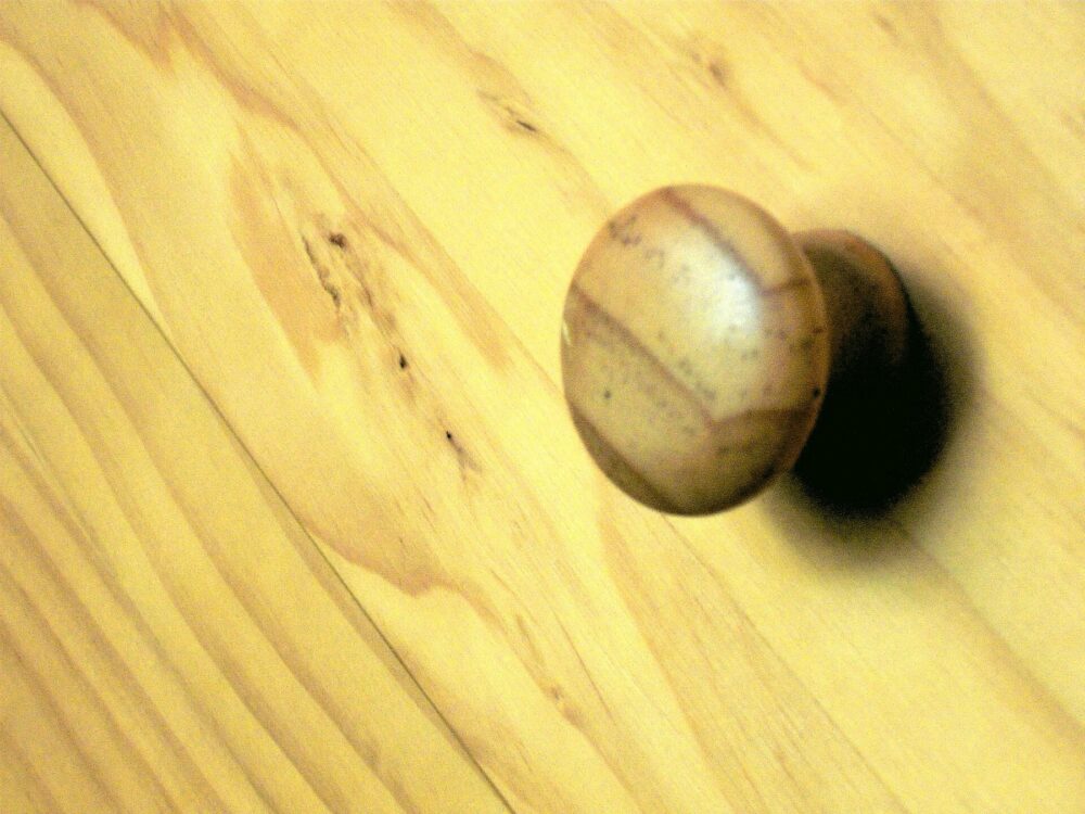 Close-up of pine chest of drawers handle showing wood grain and hardware
