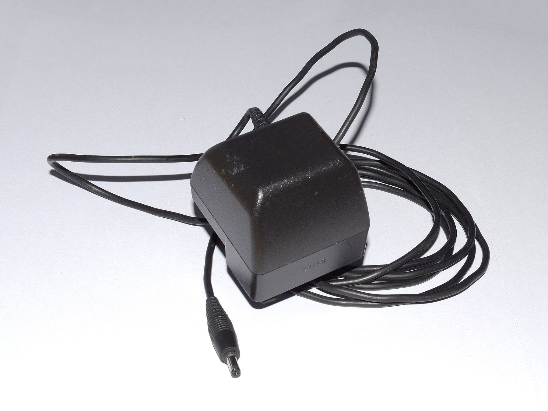 Close-up view of a classic phone charger plugged into a UK outlet