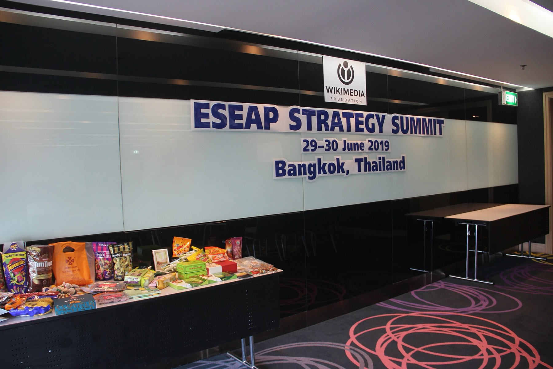 Conference table with signage and display items, similar to how wedding table signs sit beside decor.