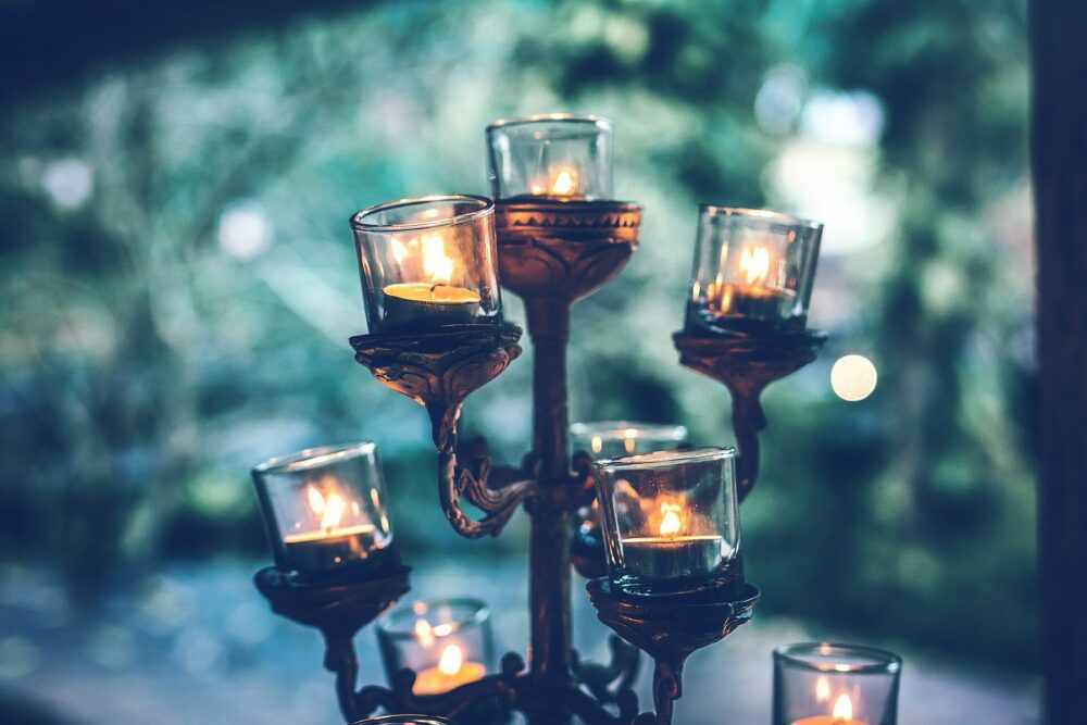 Rose gold-style candlesticks with lit candles on a table