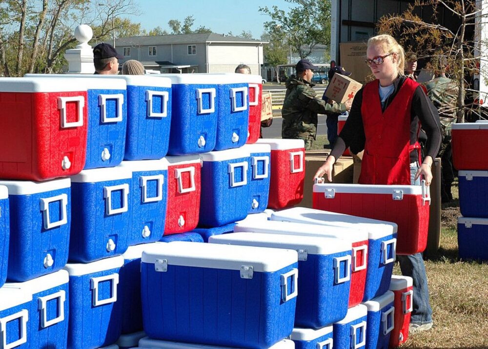 Stacked hard coolers being organized by a volunteer