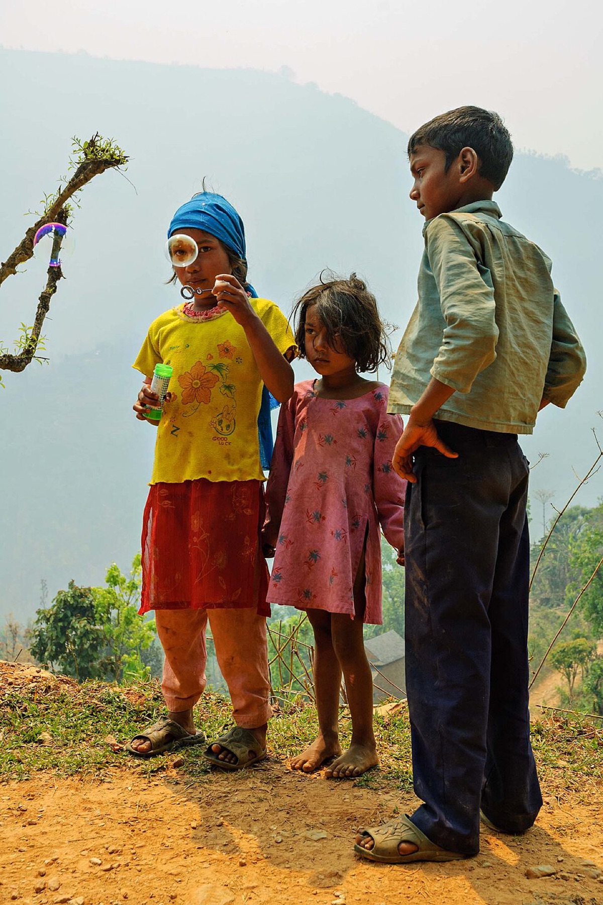 Children watching soap bubbles from a bubble blower outdoors
