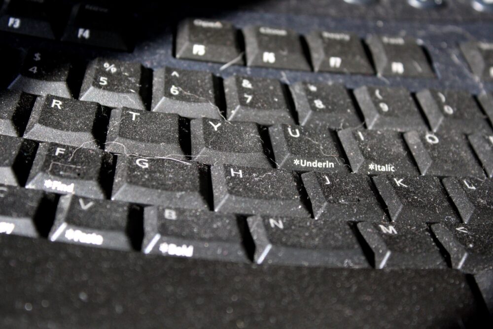 Close-up of a dusty computer keyboard, highlighting the need for proper accessories and maintenance when sourcing aesthetic boards.