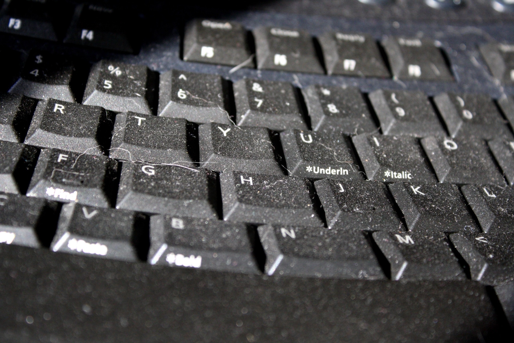 Close-up of a dusty computer keyboard, highlighting the need for proper accessories and maintenance when sourcing aesthetic boards.
