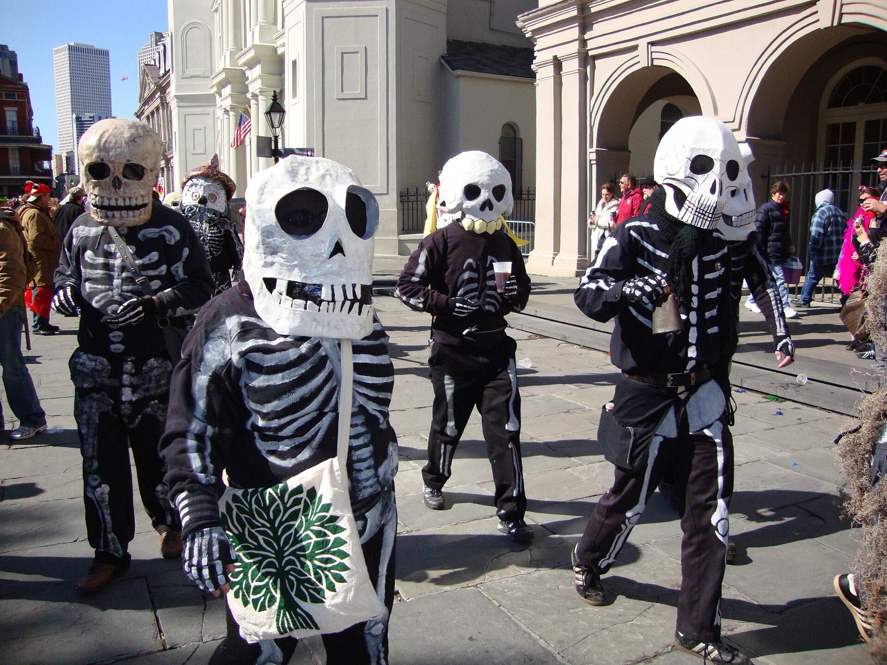 Mardi Gras revelers in elaborate skeleton costumes near Jackson Square