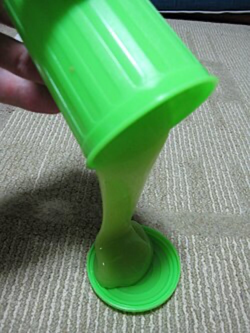 Colorful slime being poured from a container, illustrating the need to test texture and consistency before committing to bulk orders.