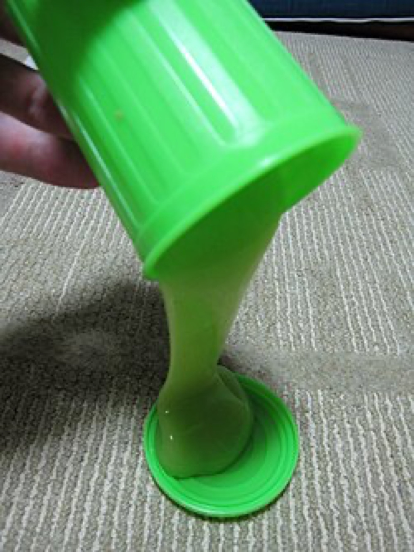 Colorful slime being poured from a container, illustrating the need to test texture and consistency before committing to bulk orders.