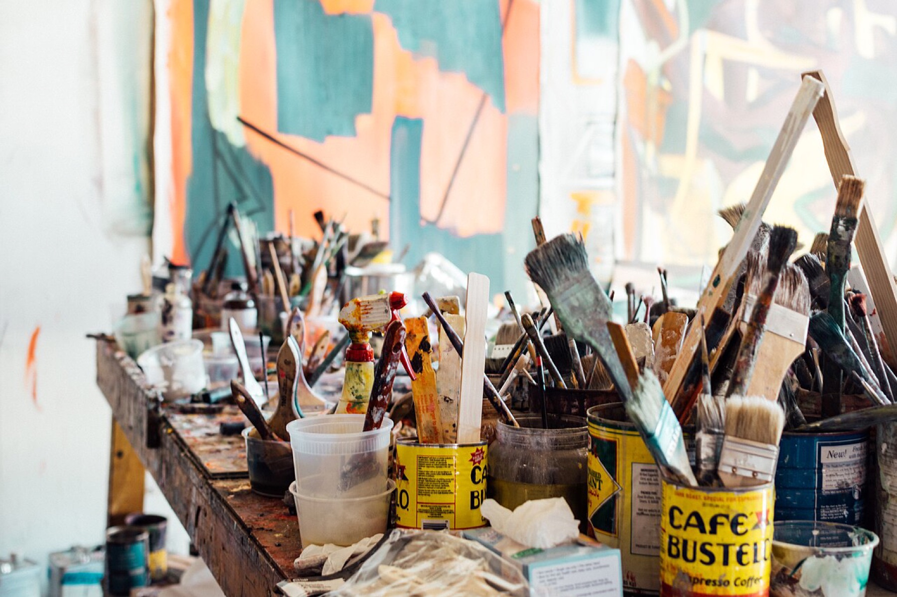 Bulk art supplies and containers spread across a work surface