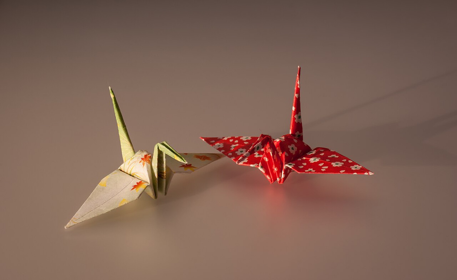 Folded origami cranes illustrating different paper types