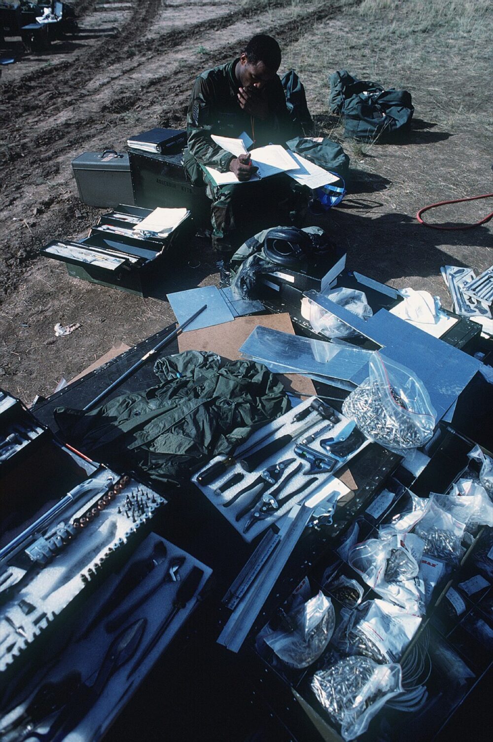 Technician reviewing parts and repair documentation surrounded by tools