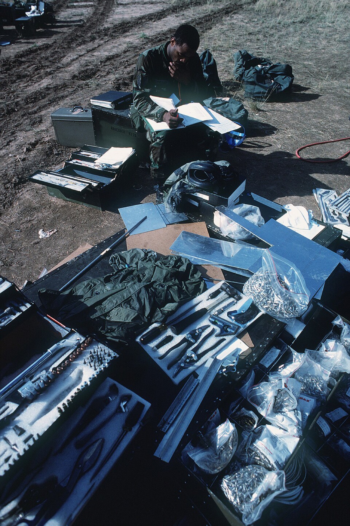 Technician reviewing parts and repair documentation surrounded by tools