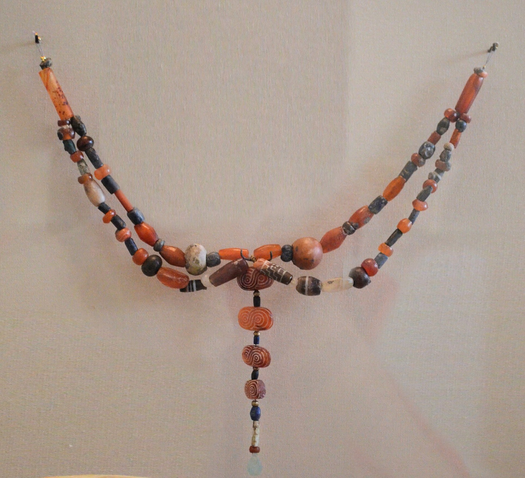 Assorted ancient jewelry components displayed together, illustrating the variety of beads and metal elements that can appear in one supply chain.