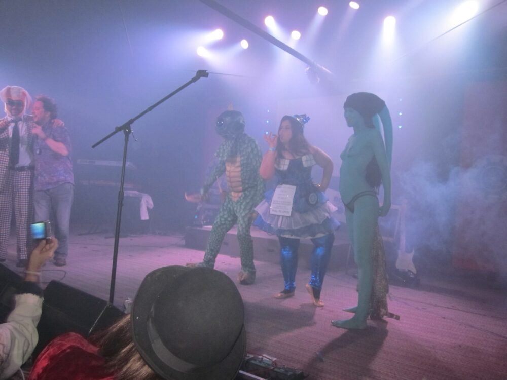Contestants in wolf-themed costumes standing on a stage